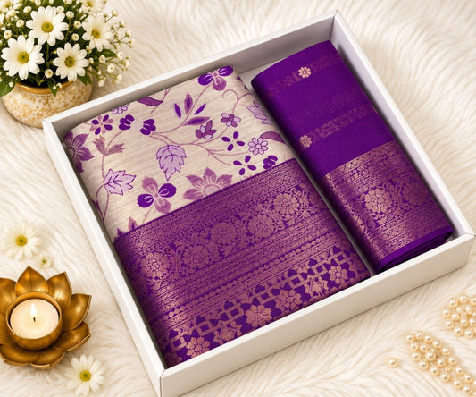 Purple Banarasi silk saree with ivory floral print body and broad gold zari purple border, shown in a white gift box with the matching purple unstitched blouse piece