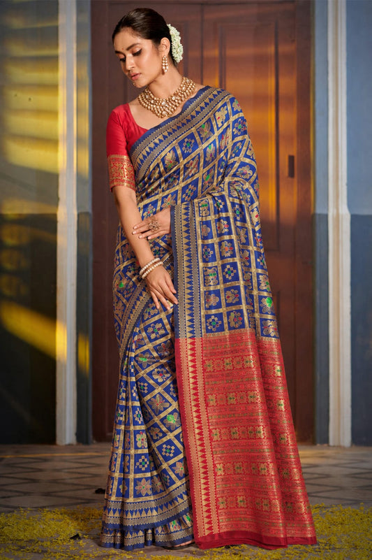Model wearing a royal blue jacquard Paithani-pattern saree with gold-tone checks and a red pallu