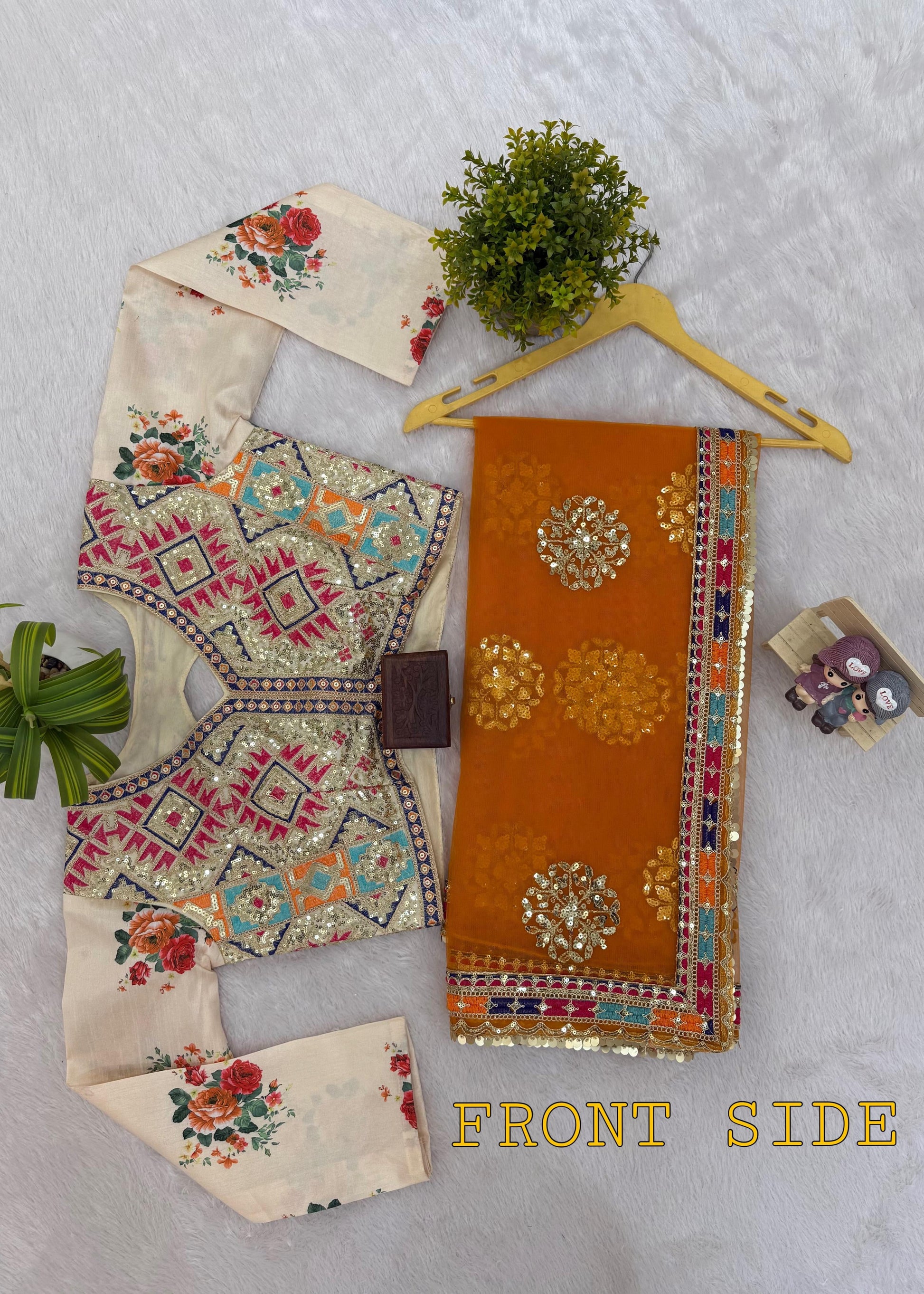 Traditional outfit with embroidered top and pants on a light gray background