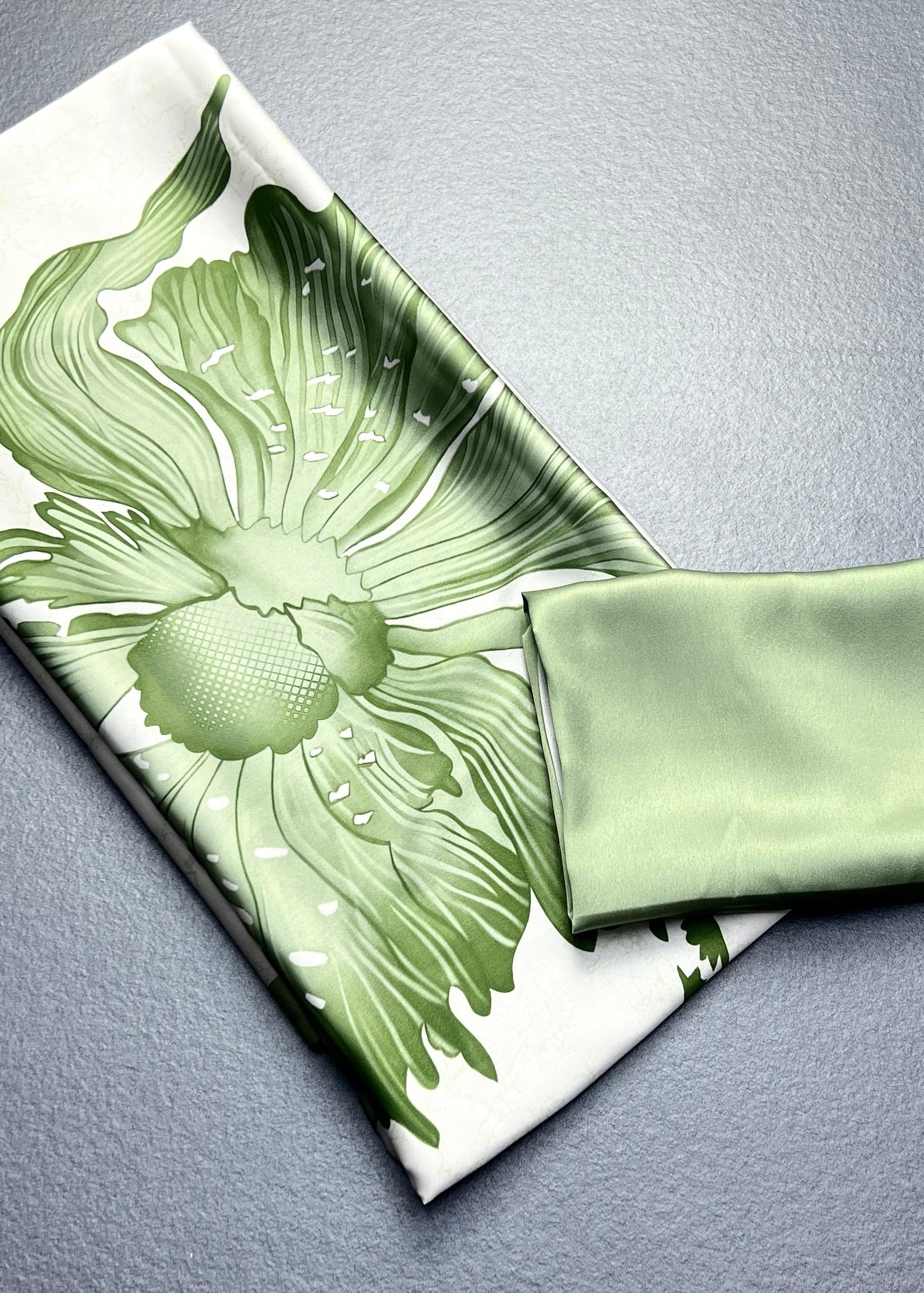 Green floral-patterned fabric on a gray surface
