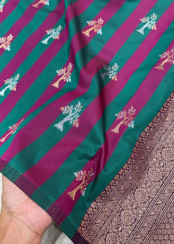 Teal and pink striped fabric with floral patterns held by a hand