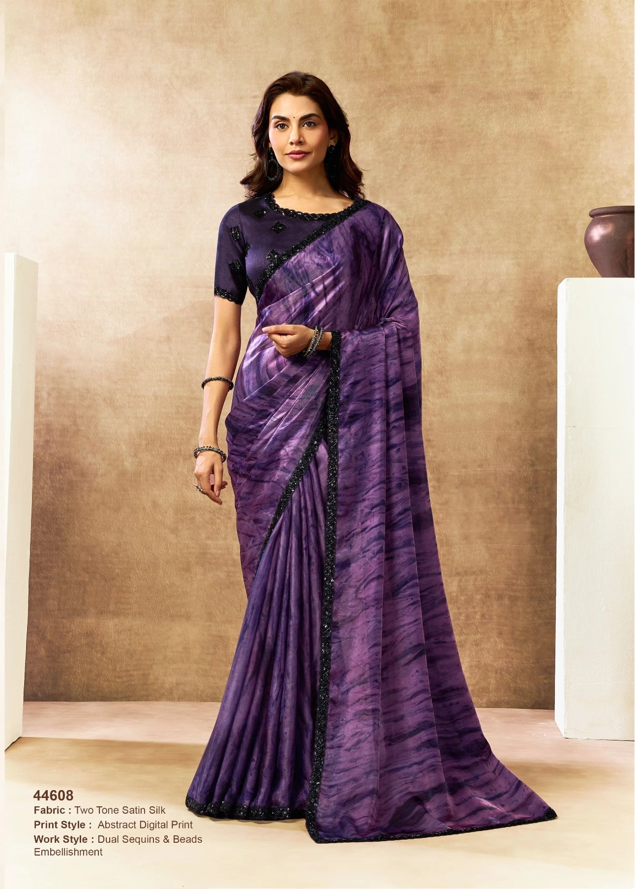 Woman wearing a purple saree with a neutral background