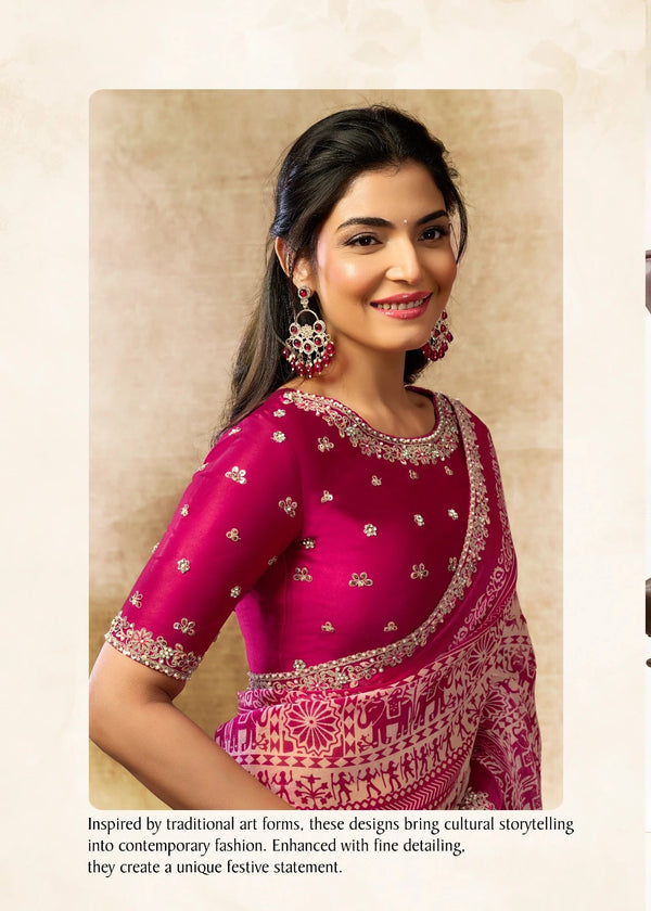 Woman wearing a pink saree with traditional patterns in an indoor setting.