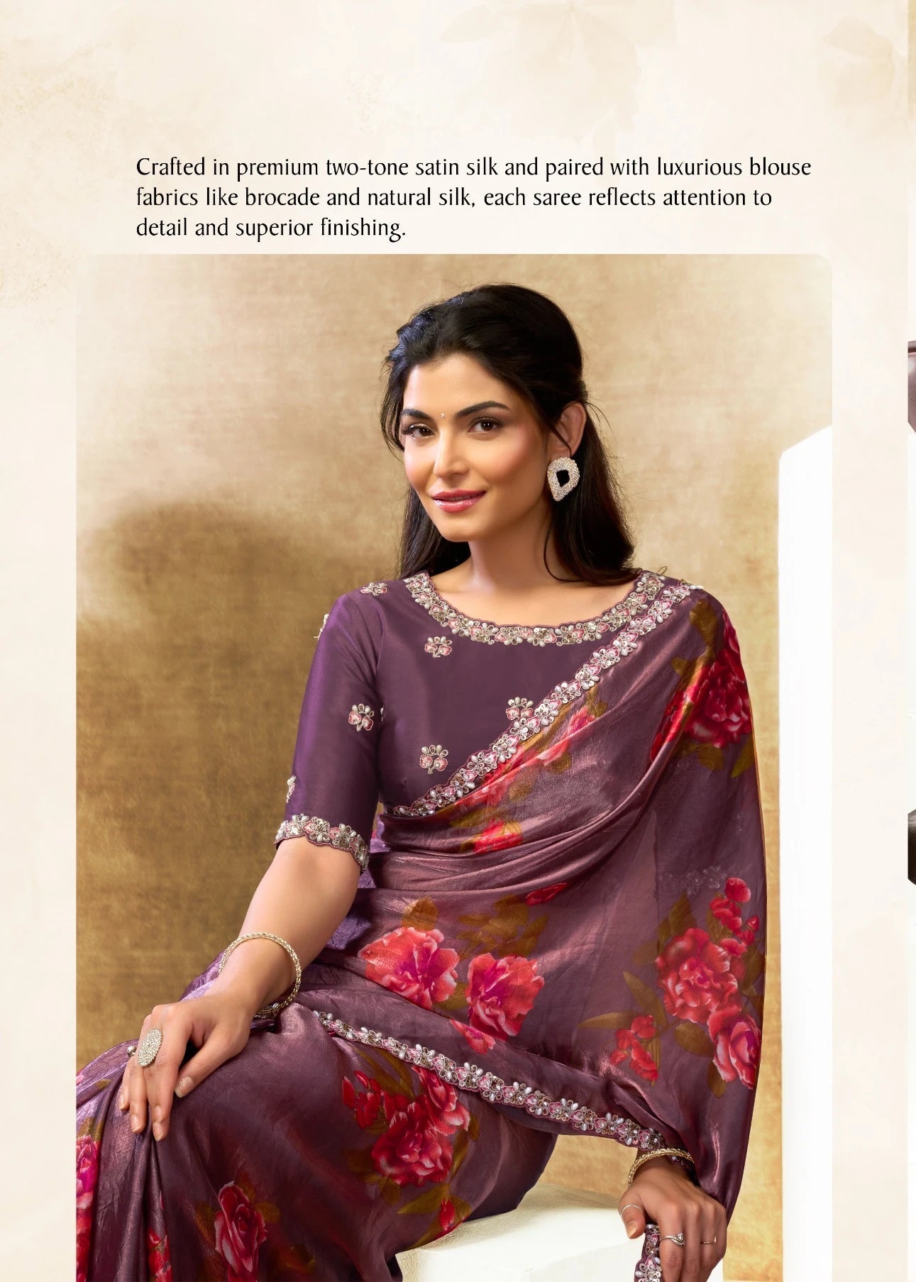 Woman wearing a purple saree with floral patterns in an indoor setting.