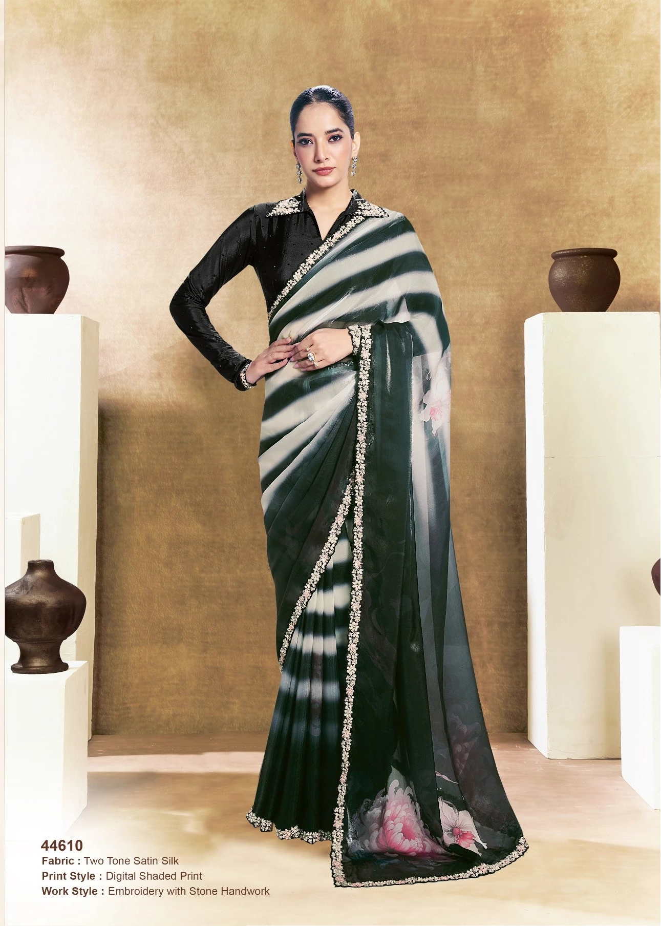 Woman wearing a black and white saree with a gold border, posing indoors.