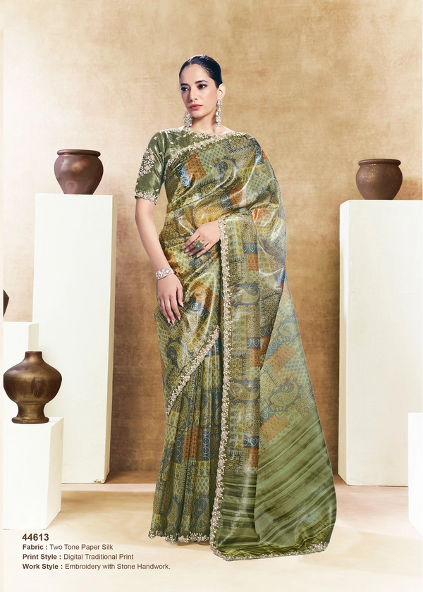 Woman wearing a green saree with a pattern, sitting and standing against a neutral background.