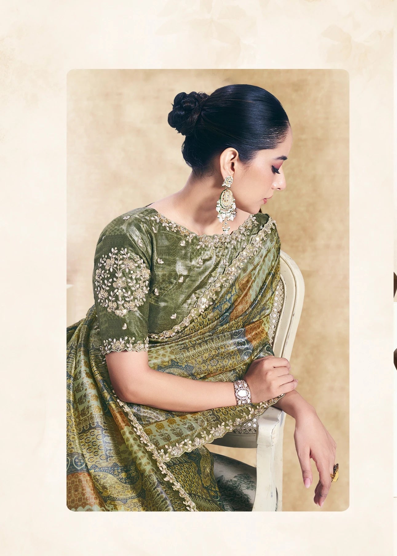 Woman wearing a green saree with a pattern, sitting and standing against a neutral background.