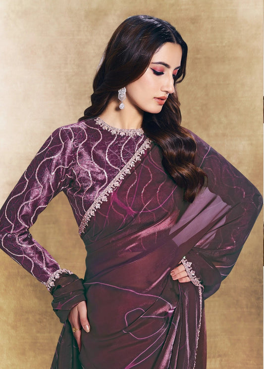 Woman wearing a purple saree with a gold border in an indoor setting.