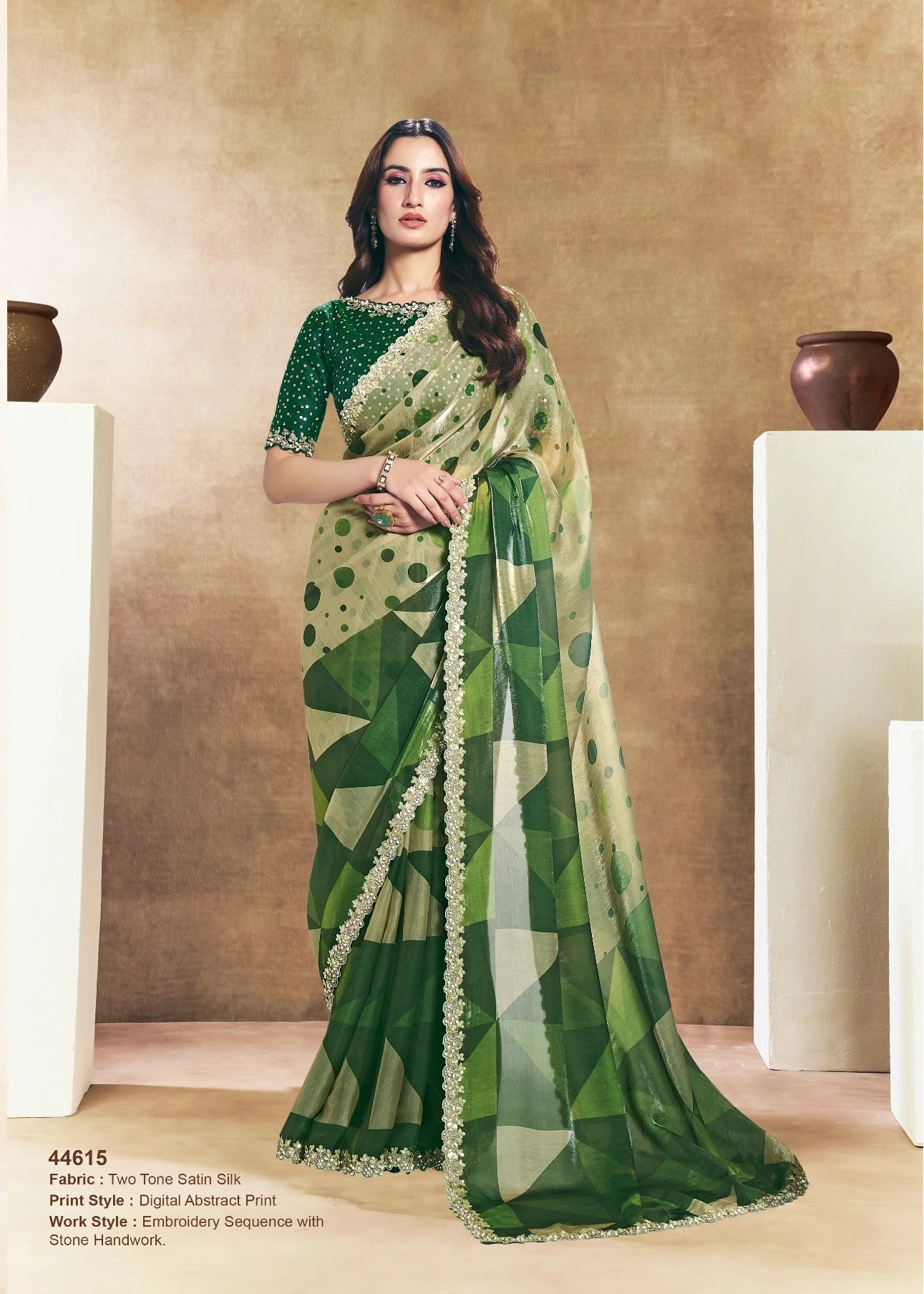Two women wearing green sarees with leaf patterns against a beige background.