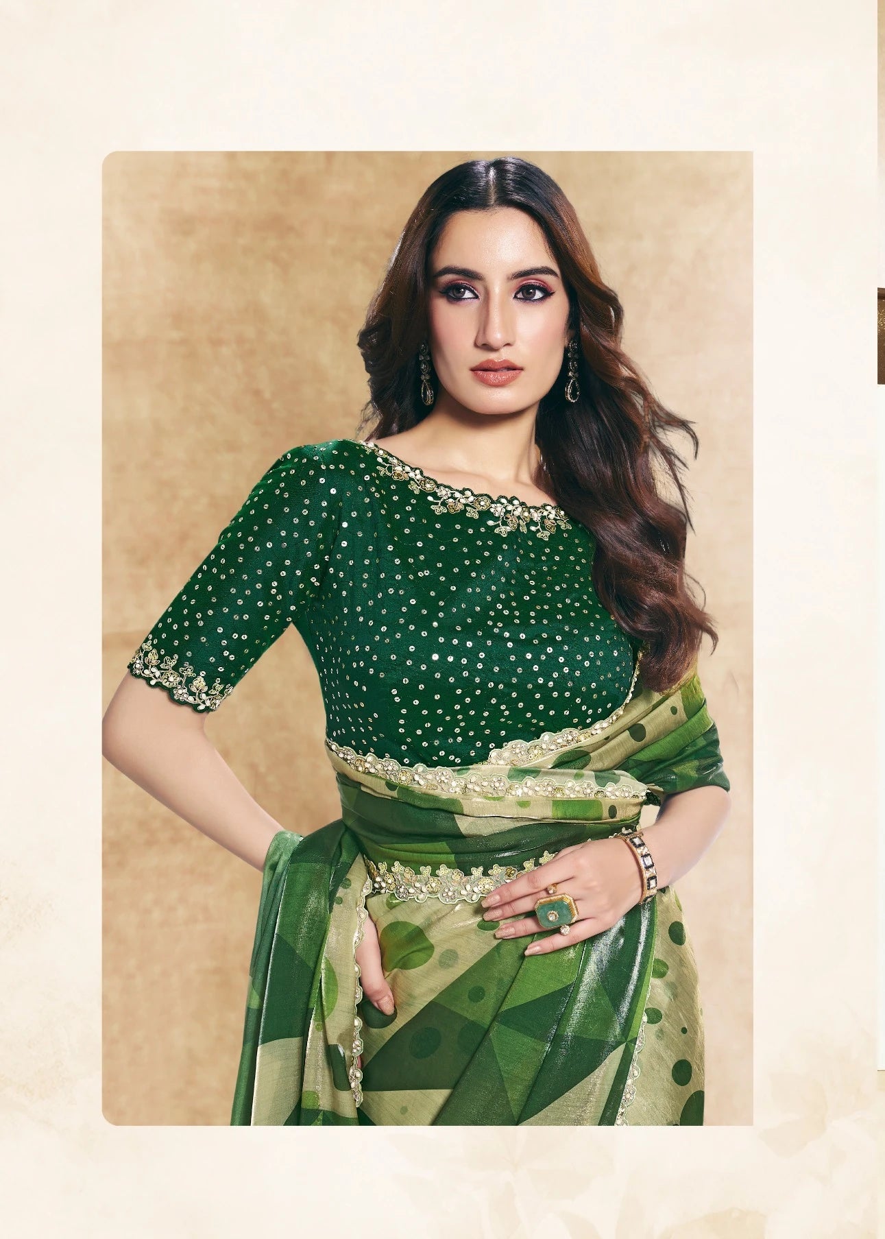 Two women wearing green sarees with leaf patterns against a beige background.