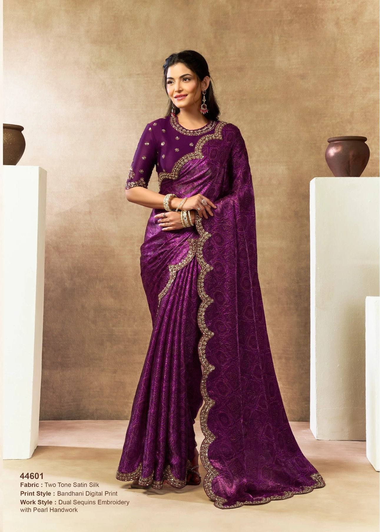 Woman wearing a purple saree with gold embroidery in an indoor setting.