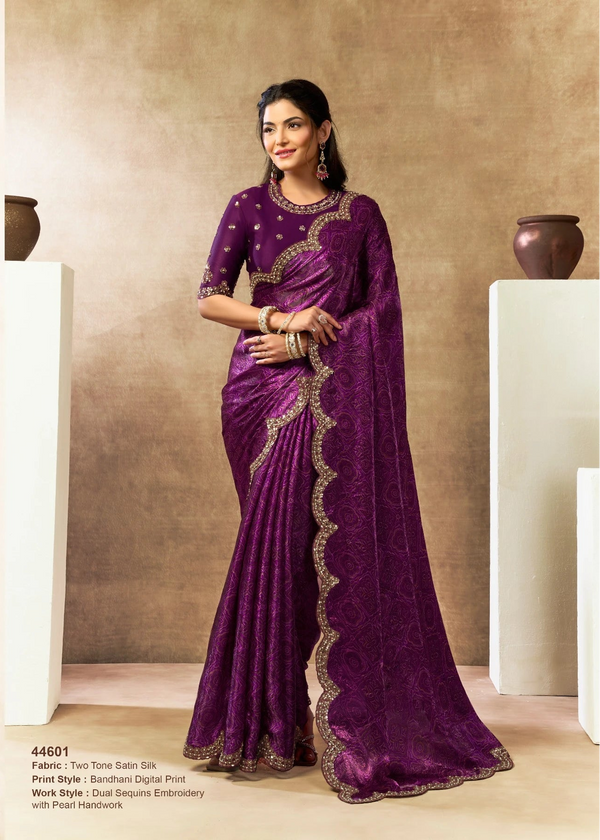 Woman wearing a purple saree with gold embroidery in an indoor setting.
