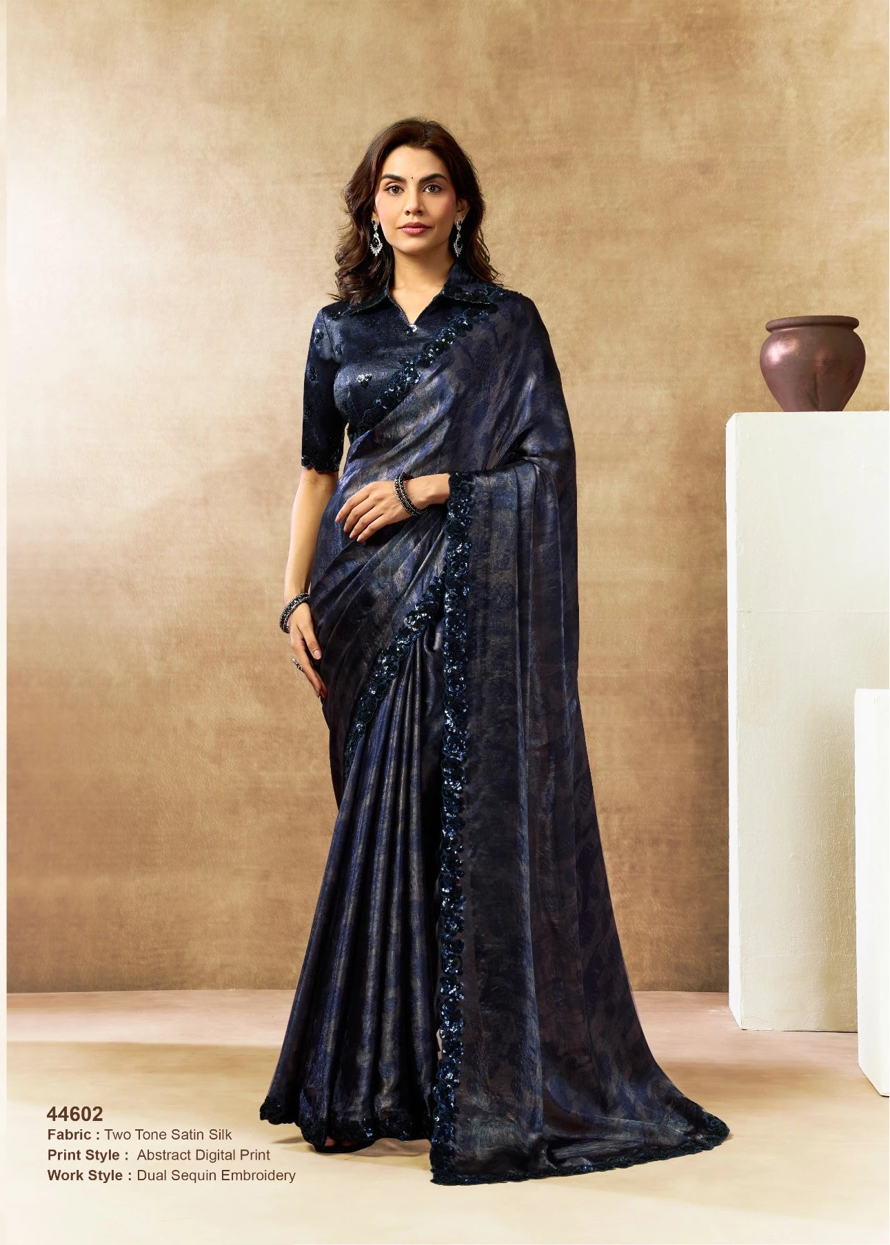 Woman wearing a black saree with a plain background
