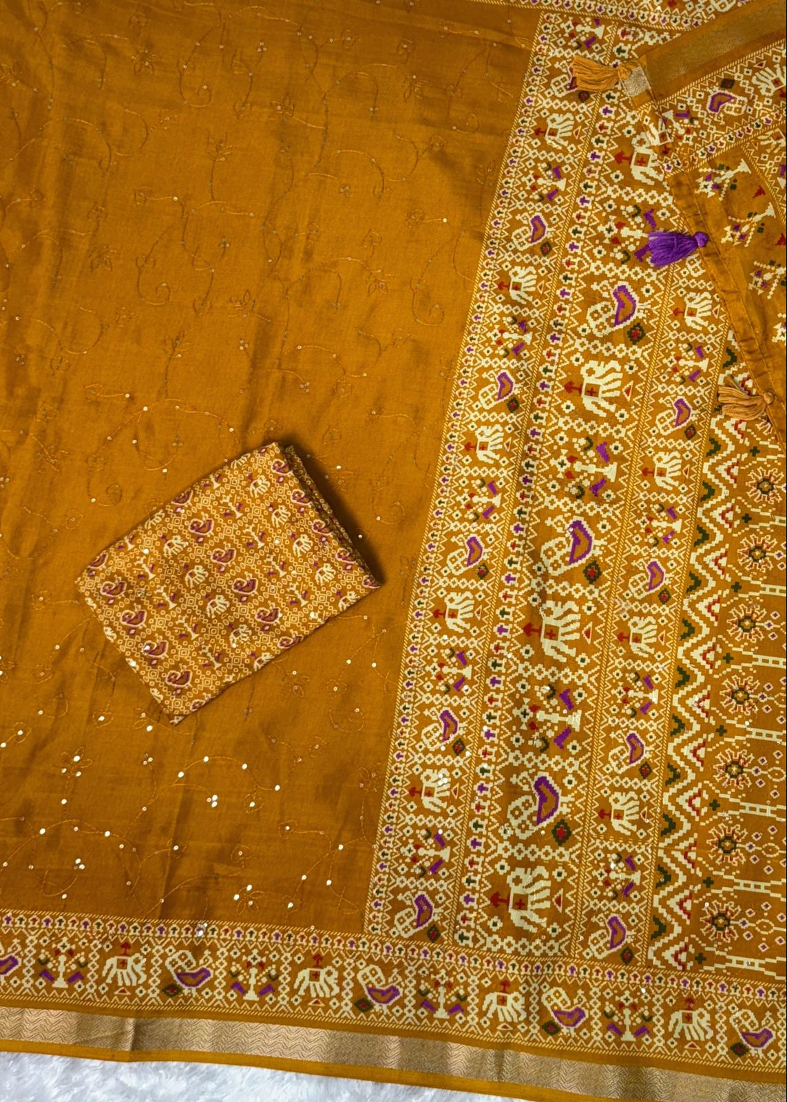 Embroidered fabric with intricate patterns on a wooden surface