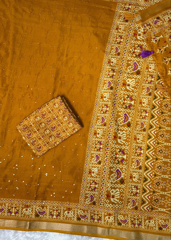 Embroidered fabric with intricate patterns on a wooden surface