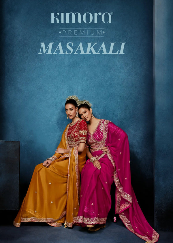 Two women in traditional sarees sitting against a blue background with 'Kimora Premium Masakali' branding.