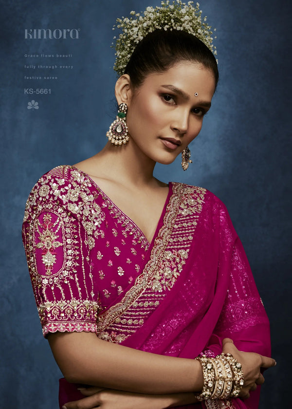 Woman wearing a pink saree with gold embroidery against a blue background