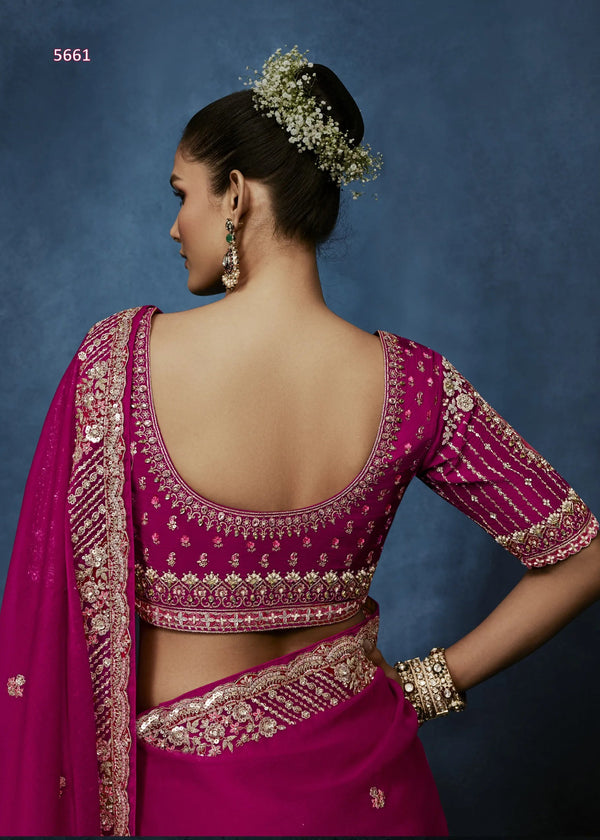 Woman wearing a pink saree with gold embroidery against a blue background