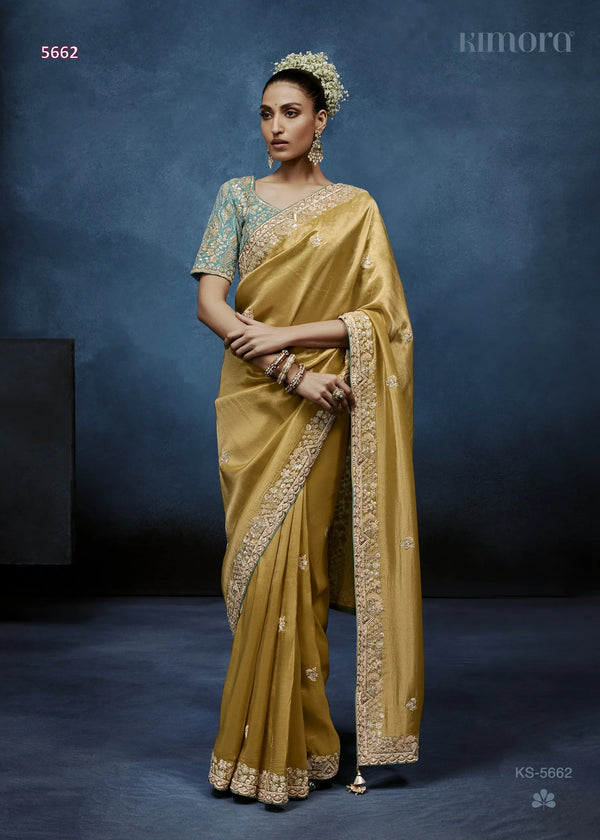 Woman in a yellow saree with a blue background