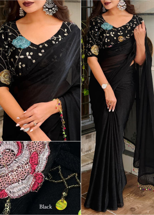 Black saree with floral and geometric patterns, worn by a model indoors.