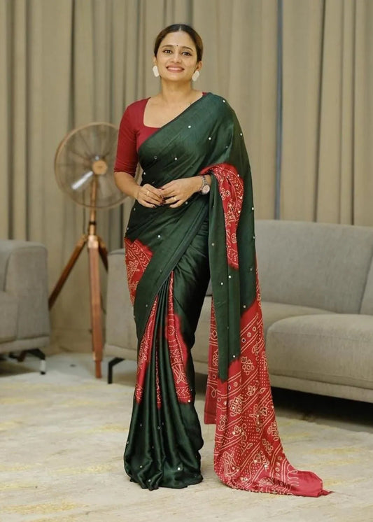 Woman wearing a green and red saree in an indoor setting