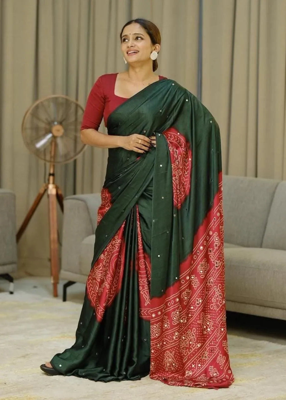 Woman wearing a green and red saree in an indoor setting