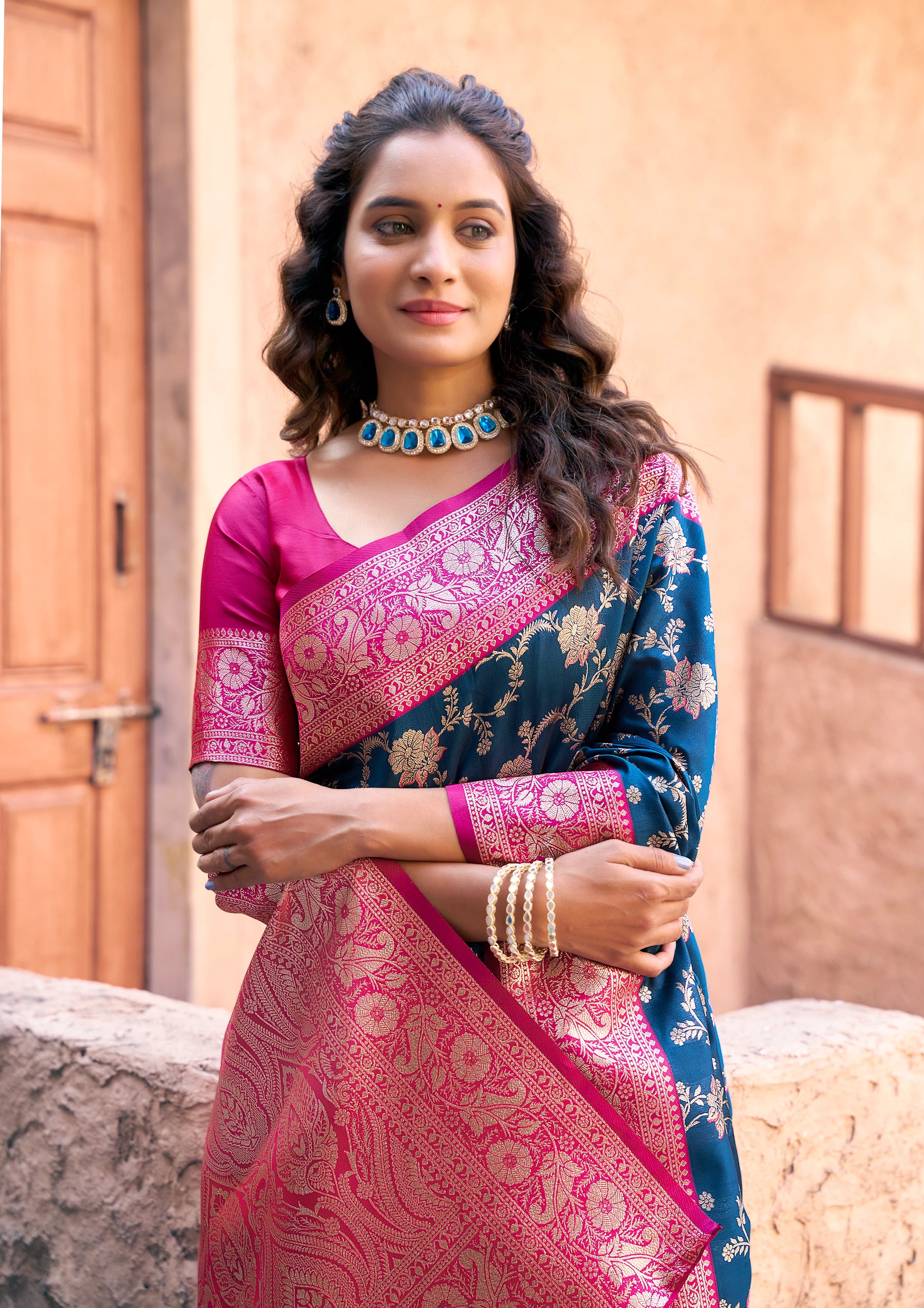 Woman wearing a traditional saree with a pink blouse in an outdoor setting