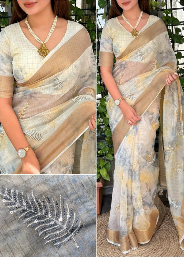 Woman wearing a beige and gray saree with a close-up of the fabric and a decorative feather design.