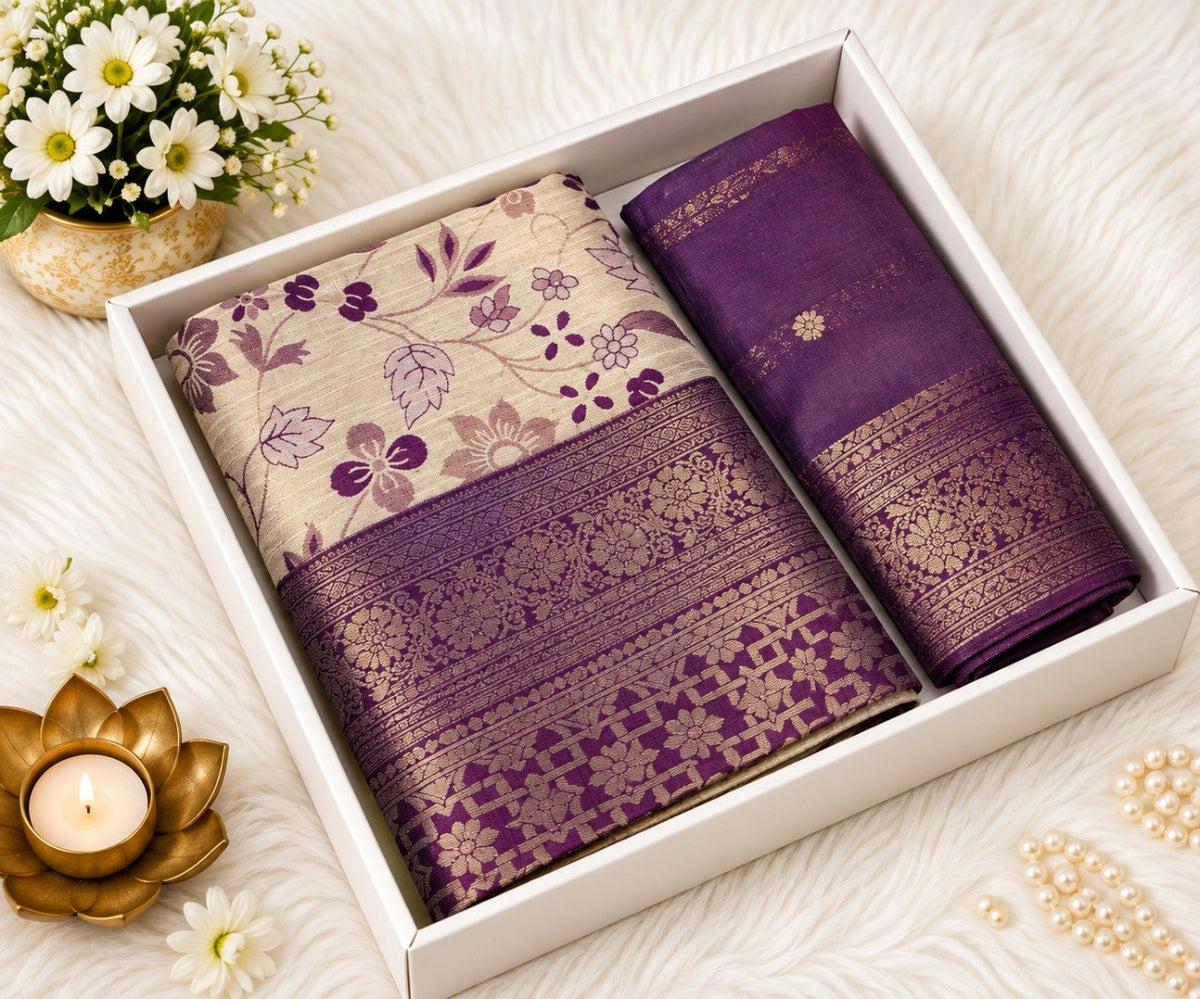 Wine Banarasi silk saree with ivory floral print body and broad gold zari wine border, shown in a white gift box with the matching wine unstitched blouse piece