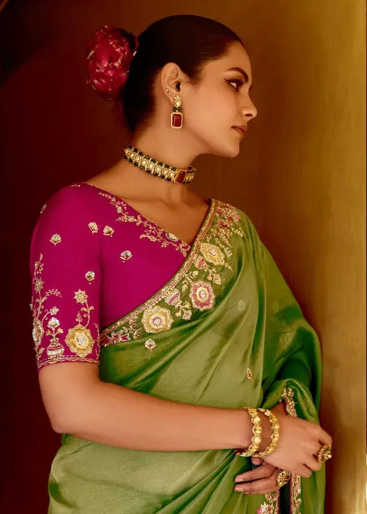 Woman wearing a green saree with pink blouse in an indoor setting
