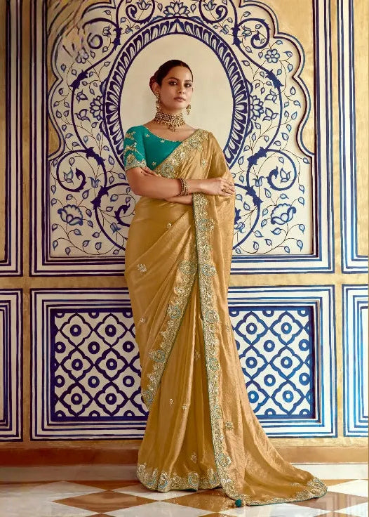 Woman in a traditional yellow saree with green blouse in an ornate room.