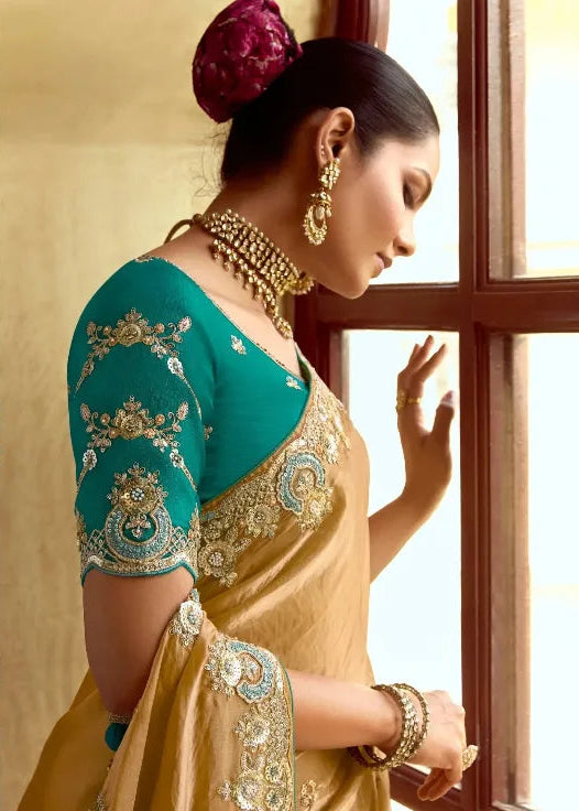 Woman in a traditional yellow saree with green blouse in an ornate room.