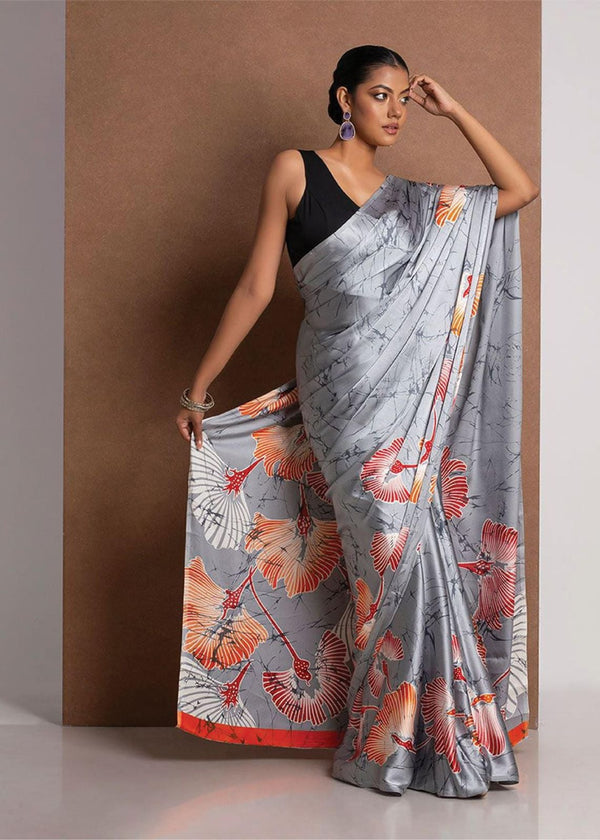 Woman wearing a floral saree with a neutral background