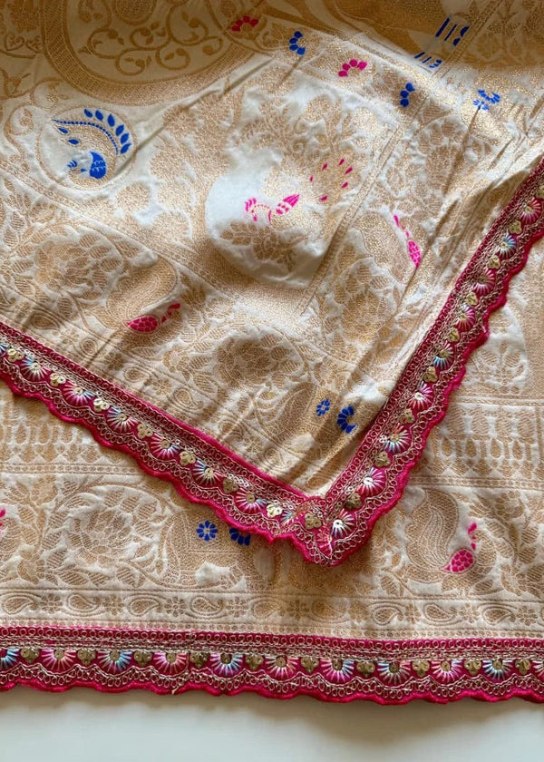 Beige fabric with intricate red and blue embroidery on a beige background