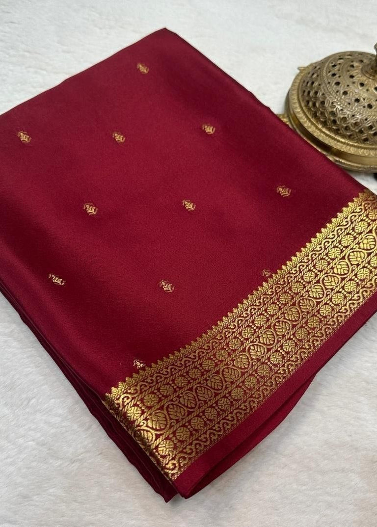 Maroon saree with gold border on a white background