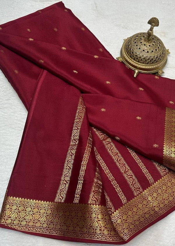 Maroon saree with gold border on a light gray background